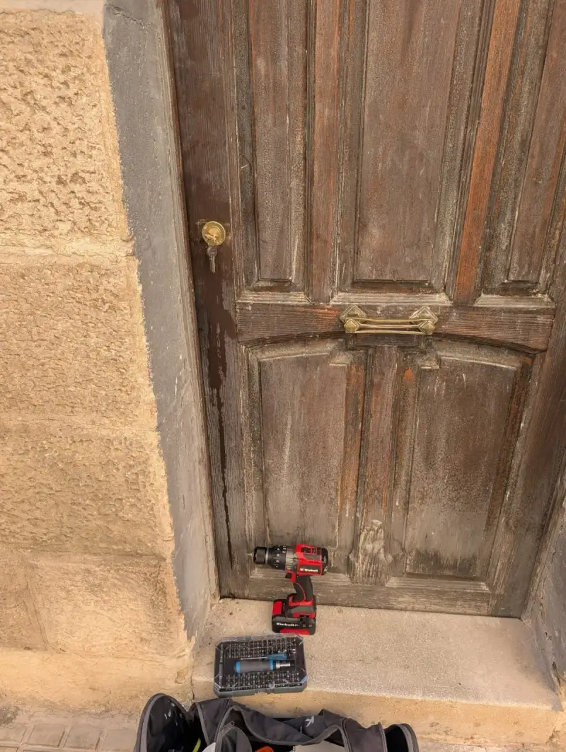 Cerrajero trabajando en la reparación de una puerta de madera en Alicante